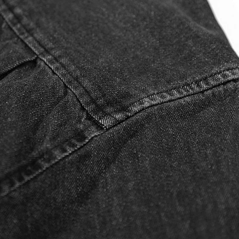 Close-up of black washed denim fabric with visible stitching and seam details, highlighting the texture and weave—ideal for an overshirt crafted from natural cotton.