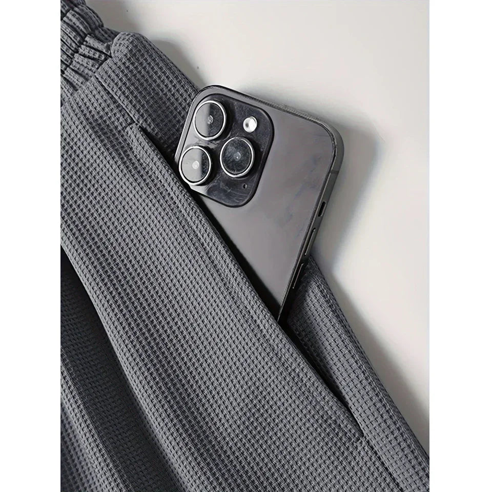 Close-up of gray textured pants pocket with smartphone, Rovelli activewear detail