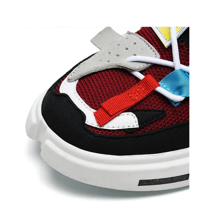 Close-up of the front part of the Extreme VS7 Sneakers with a white sole, red mesh upper, black trim, grey and white overlays, and blue and red decorative straps—perfect lightweight breathable sneakers for streetwear style.