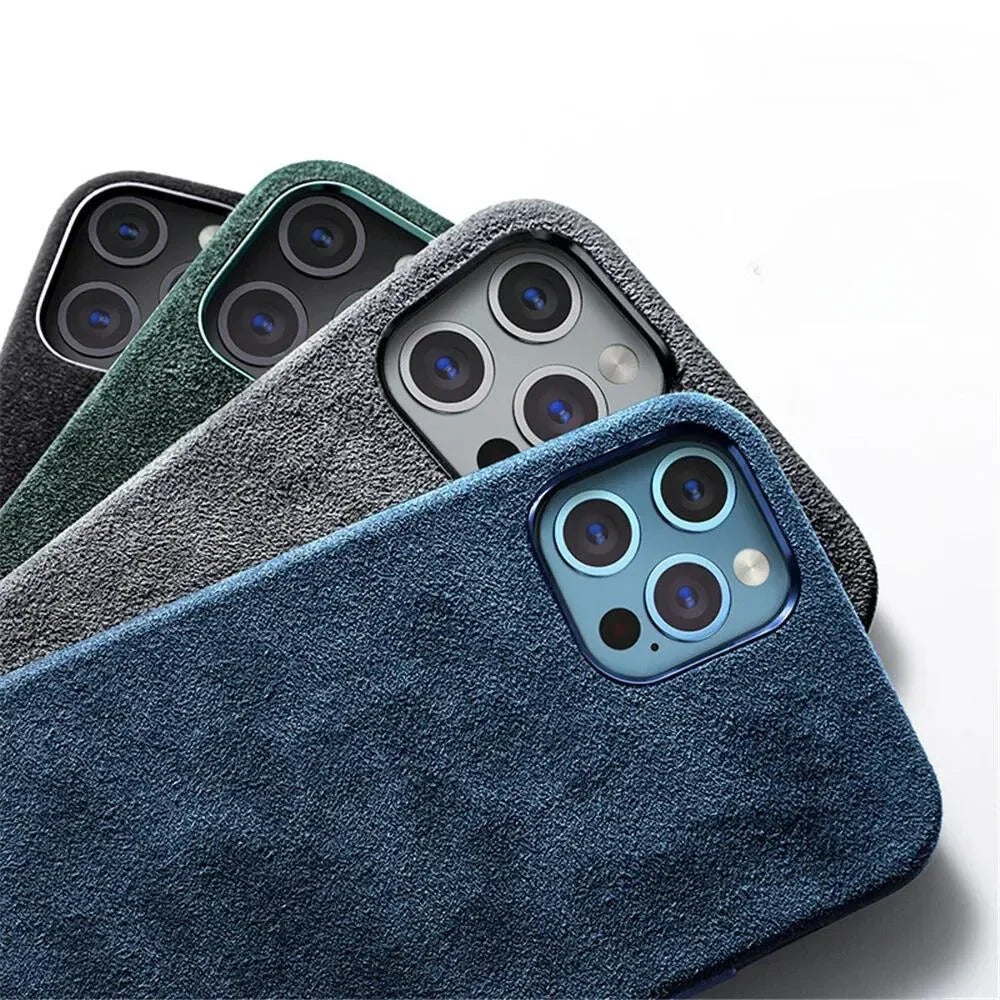Four smartphones in textured alcantara phone cases—blue, gray, green, and black—are arranged diagonally with their camera lenses visible, showcasing the suede finish of each protective design against a white background.