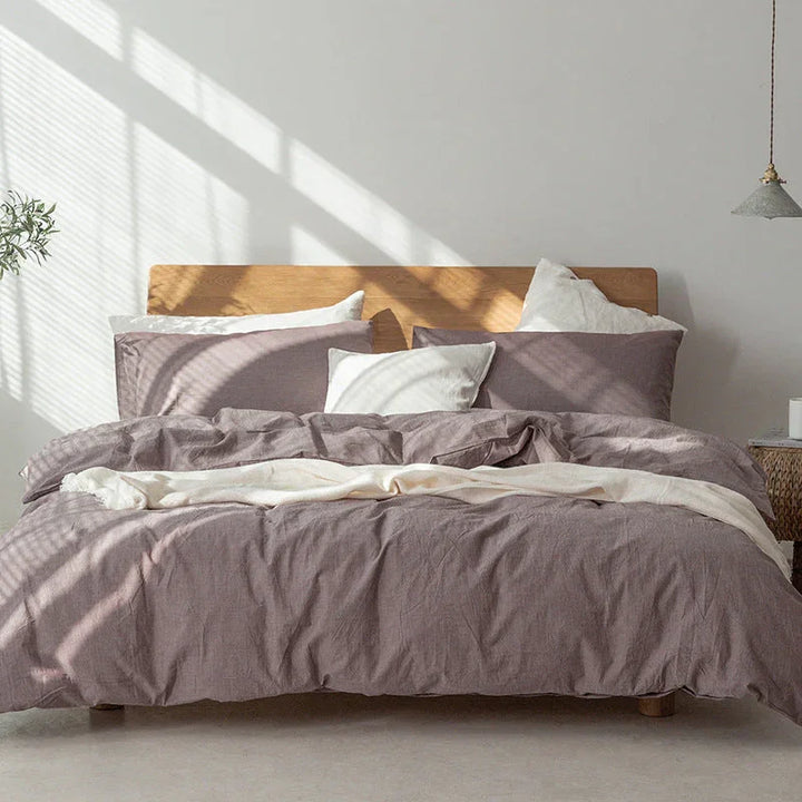Rovelli bed with mauve linen bedding and white pillows in sunlit minimalist bedroom