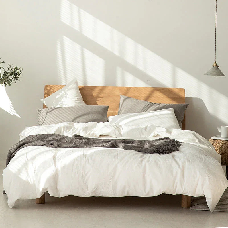 Modern bedroom with wooden bed frame, white bedding, gray blanket, sunlight, Rovelli home style
