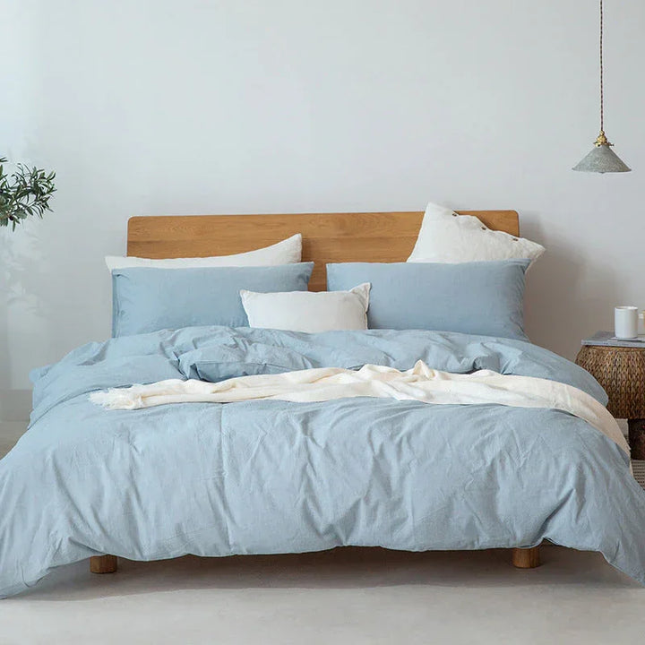 Light blue bedding set on a wooden bed frame in a modern Rovelli bedroom