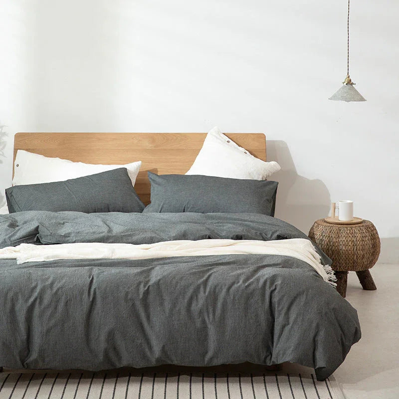 Rovelli modern bedroom with grey bedding, wooden headboard, and woven nightstand