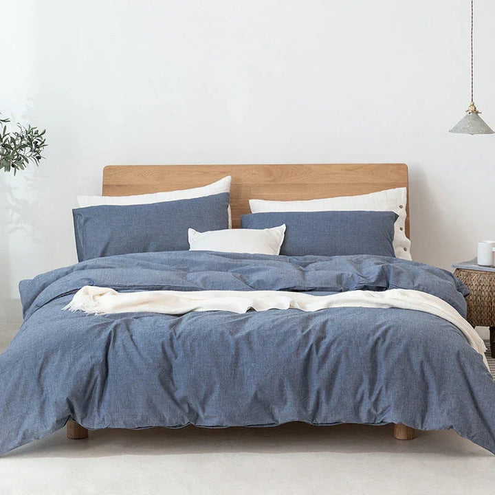 Modern bedroom with wooden bed frame, blue and white bedding set, and minimalist decor at Rovelli