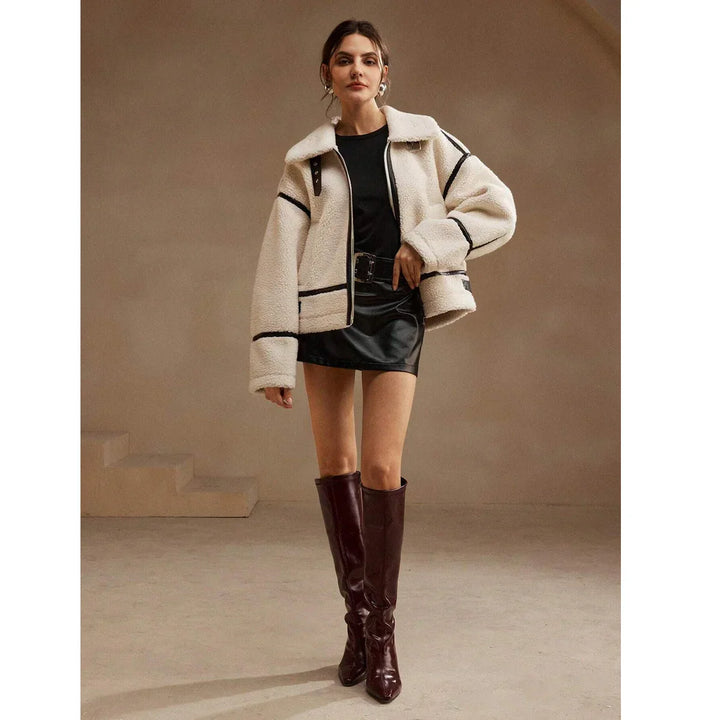 Fashion model wearing a cream shearling jacket, black mini skirt, and burgundy boots, Rovelli