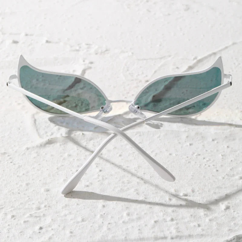 A pair of sunglasses with light blue, wing-shaped polarized lenses and white frames sits on a textured white surface with the lightweight arms crossed.