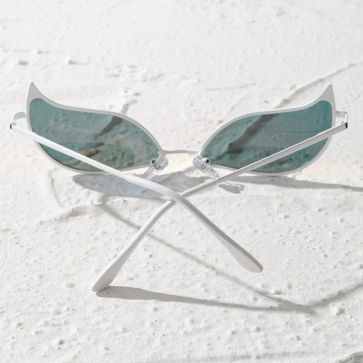 A pair of sunglasses with light blue, wing-shaped polarized lenses and white frames sits on a textured white surface with the lightweight arms crossed.