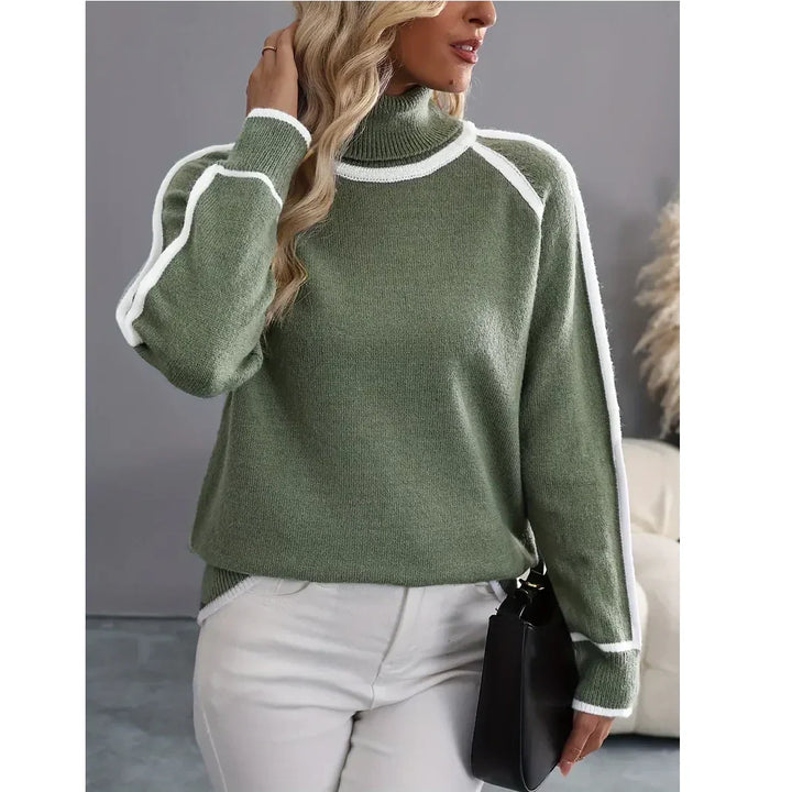 Woman wearing green turtleneck sweater with white trim, white pants, holding black bag, Rovelli