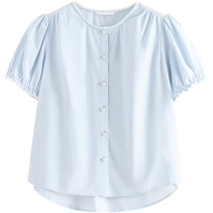 Light blue short-sleeved button-up blouse with puffed sleeves, white decorative trim at the collar and sleeve edges, and a slightly curved hem. This versatile blouse features soft, lightweight fabric for all-day comfort.