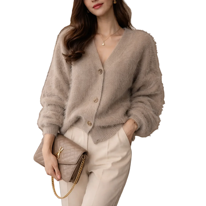 Woman in beige fuzzy cardigan and cream pants holding quilted purse, Rovelli fashion