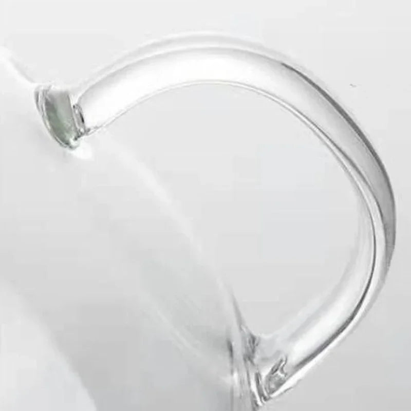 Close-up of an ergonomic handle seamlessly attached to a heat-resistant glass teapot, set against a plain white background.