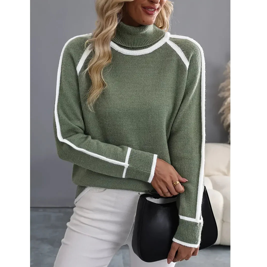 Woman in green turtleneck sweater with white trim, white pants, holding black bag, Rovelli
