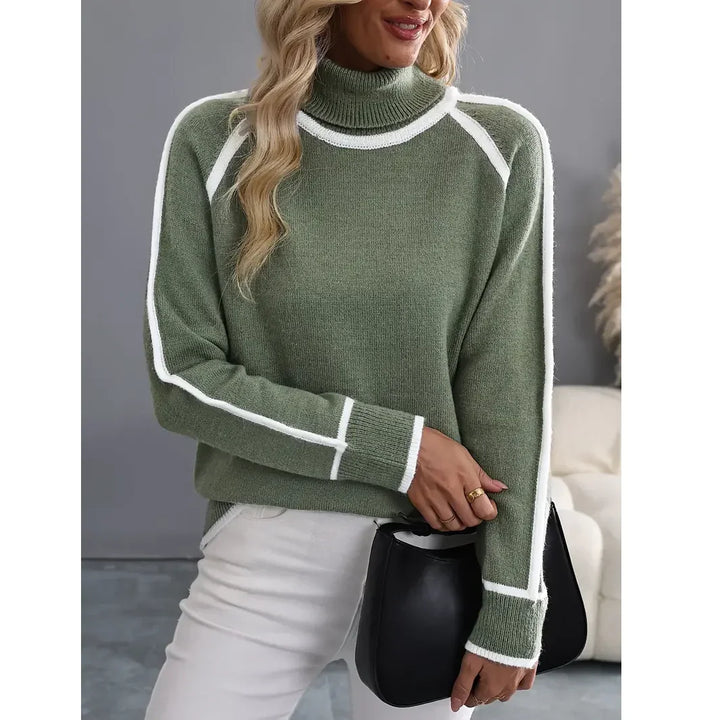 Woman in green turtleneck sweater with white trim, white pants, holding black bag, Rovelli