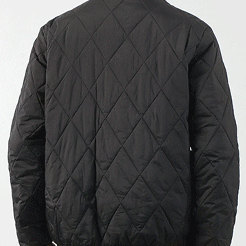A person wearing a black padded jacket, shown from the back. The jacket features a diamond-stitched pattern and has a slightly loose fit. The background is plain and light-colored.