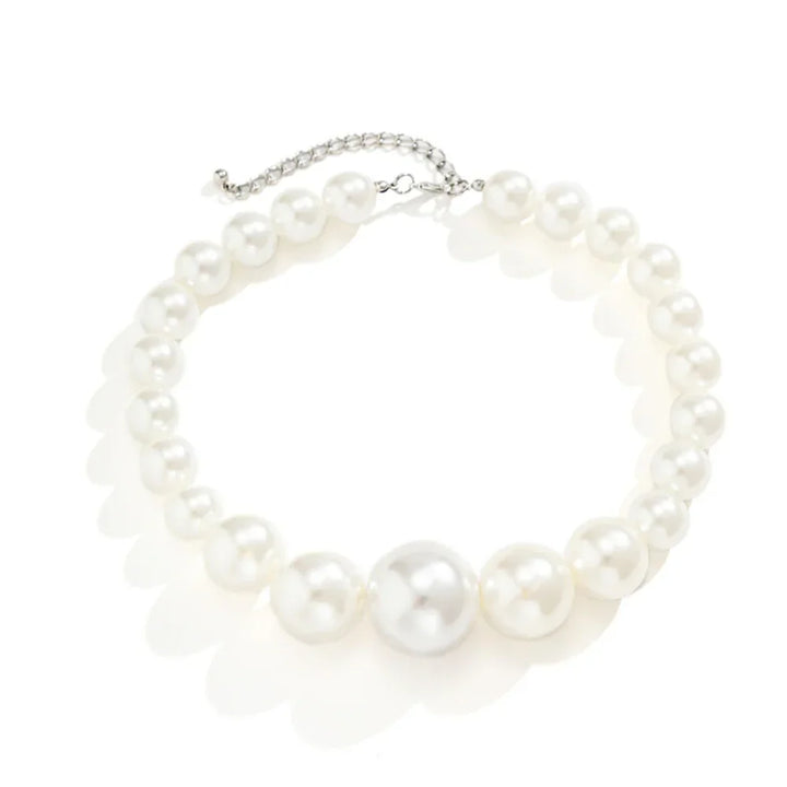 A statement jewelry piece, this pearl necklace features large, round white pearls with a larger central pearl and a silver adjustable chain clasp, making it a standout addition to any pearl jewelry set. Displayed on a white background.