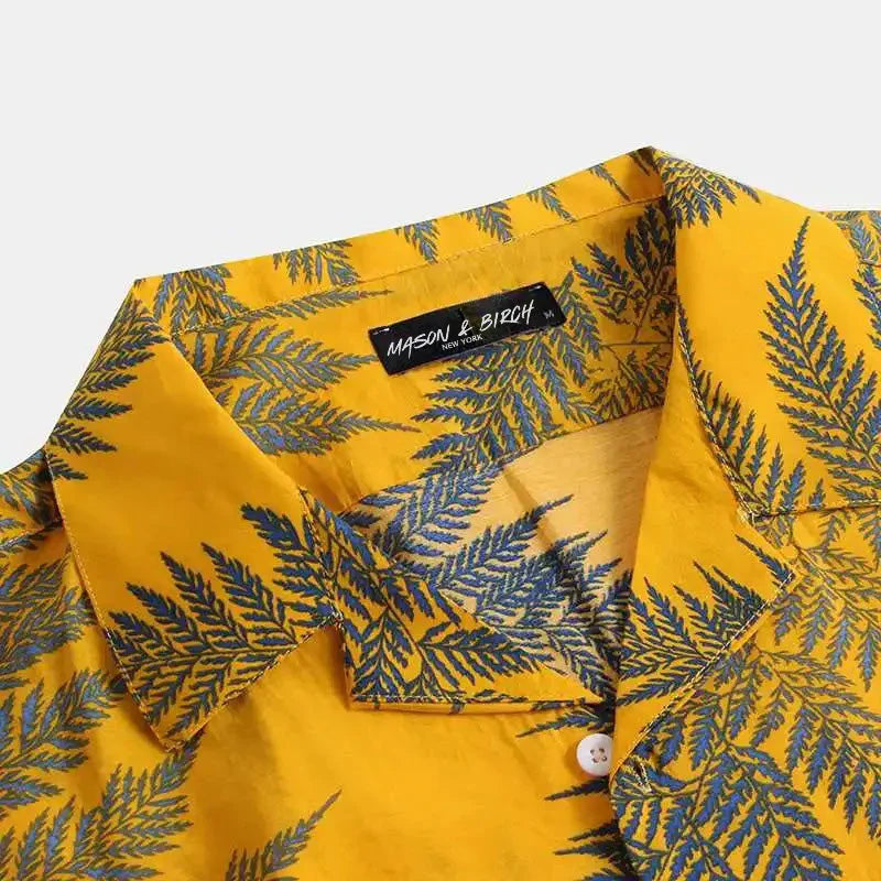 A yellow cotton shirt with a classic design, featuring blue fern leaf patterns. The brand label inside the collar reads MASON & BIRCH. The shirt is buttoned and displayed against a plain background—ideal for a casual brunch.