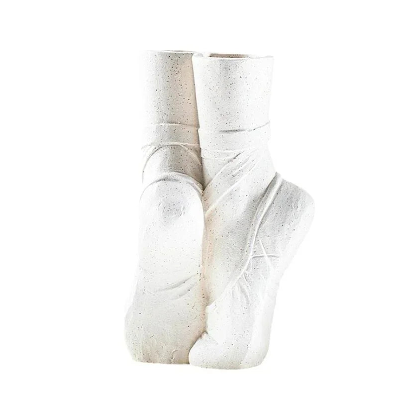 A ballet-inspired vase shaped like two ballet slippers standing upright, with detailed lines and satin-like textures—perfect for adding contemporary chic décor to any space.
