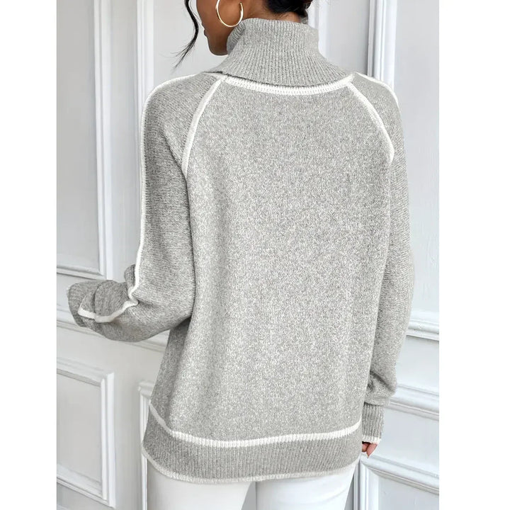 Woman wearing a grey turtleneck sweater with white trim, Rovelli fashion style