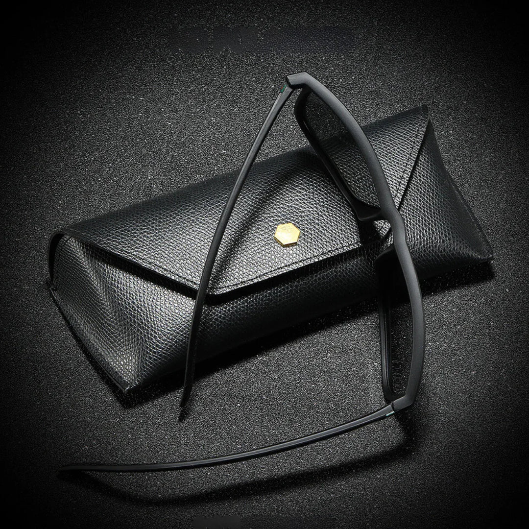 A pair of black-rimmed eyeglasses rests against a textured black eyeglass case with a small gold hexagonal emblem, all set on a black, slightly sparkly surface—perfect for storing your stylish sunglasses.