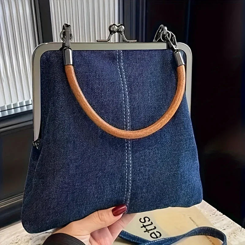 Rovelli denim handbag with wooden handle and metal frame, held by hand indoors