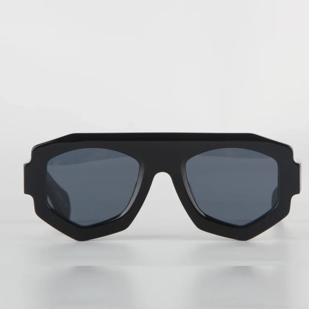 A pair of black geometric sunglasses with dark tinted lenses features a bold, angular acetate frame and offers UV400 protection, displayed against a plain white background.
