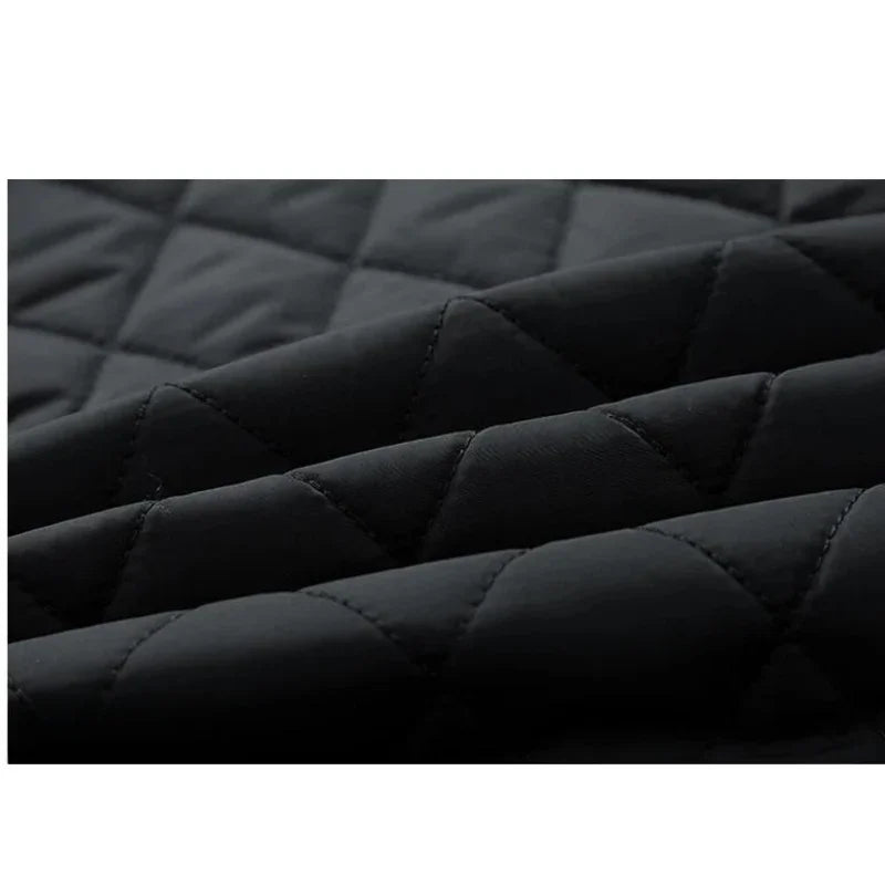 Close-up of black quilted fabric with a diamond stitch pattern, showing soft, padded texture and slightly raised seams—ideal for a slim-fit jacket with cozy cotton insulation.