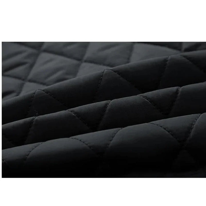 Close-up of black quilted fabric with a diamond stitch pattern, showing soft, padded texture and slightly raised seams—ideal for a slim-fit jacket with cozy cotton insulation.