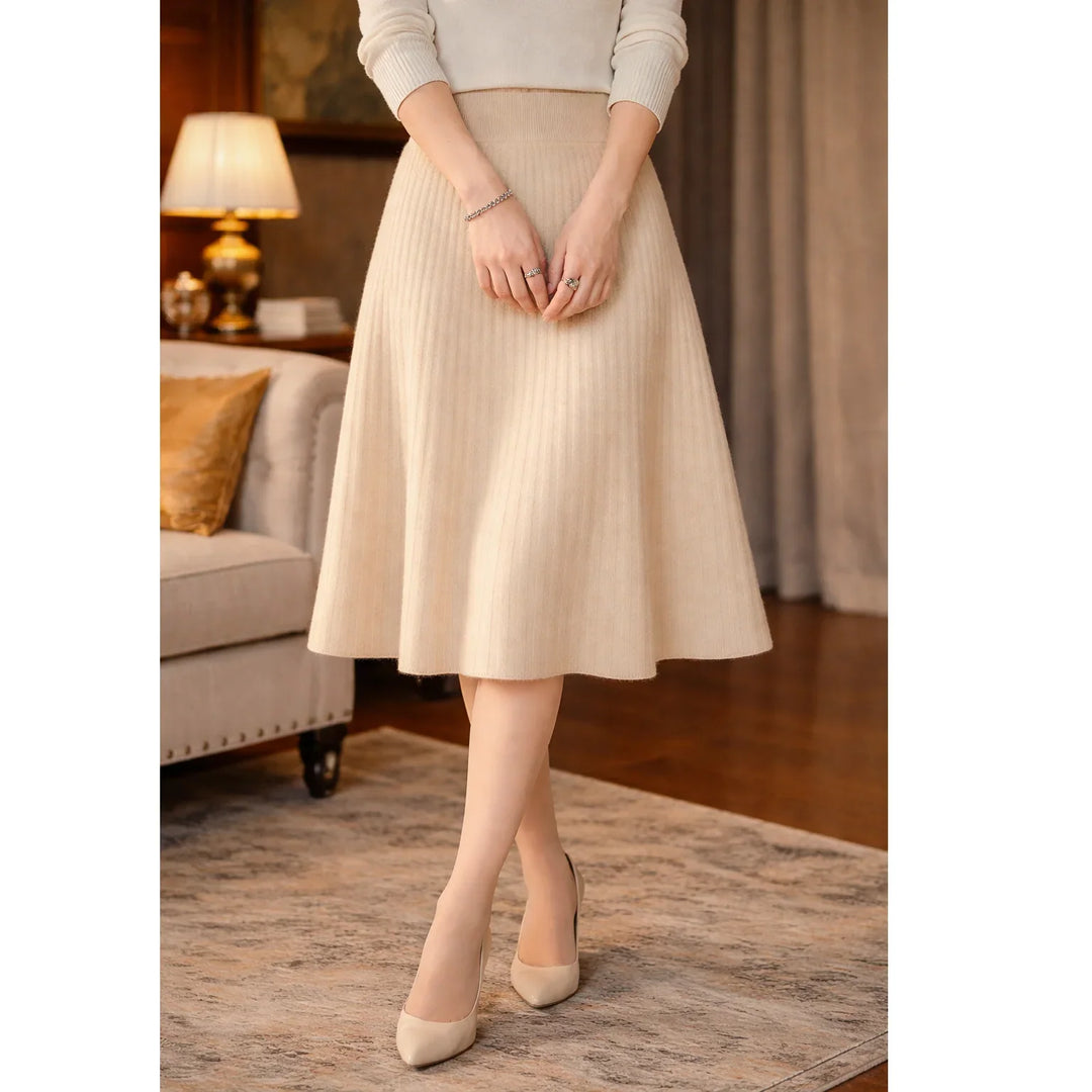 Woman in beige knit midi skirt and heels standing in elegant living room, Rovelli fashion