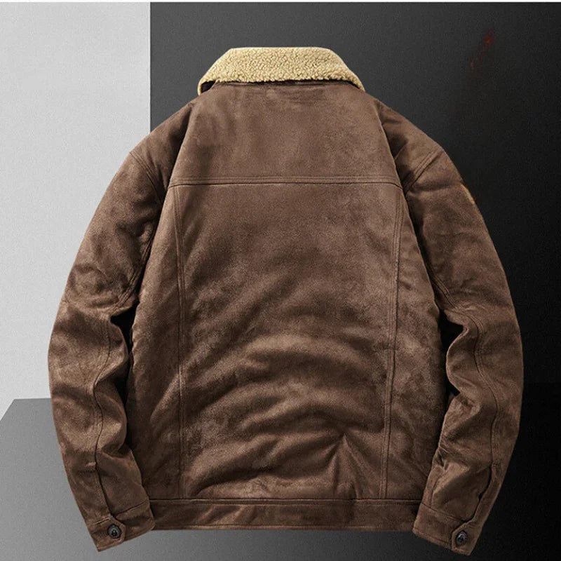 A brown suede jacket with a light shearling collar and structured fit, shown from the back. The jacket has a soft, textured appearance, buttoned cuffs, and is displayed against a two-tone background.