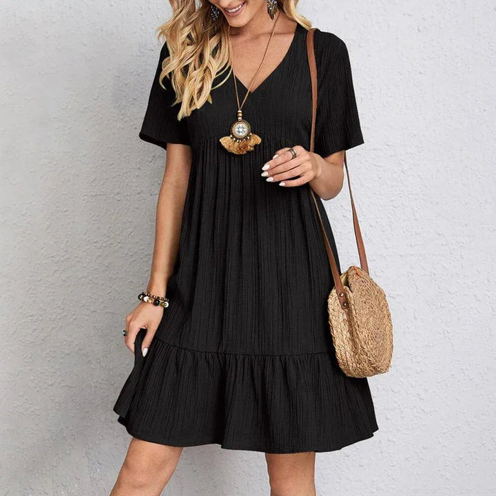 Woman wearing casual black short-sleeve dress with woven handbag, Rovelli fashion