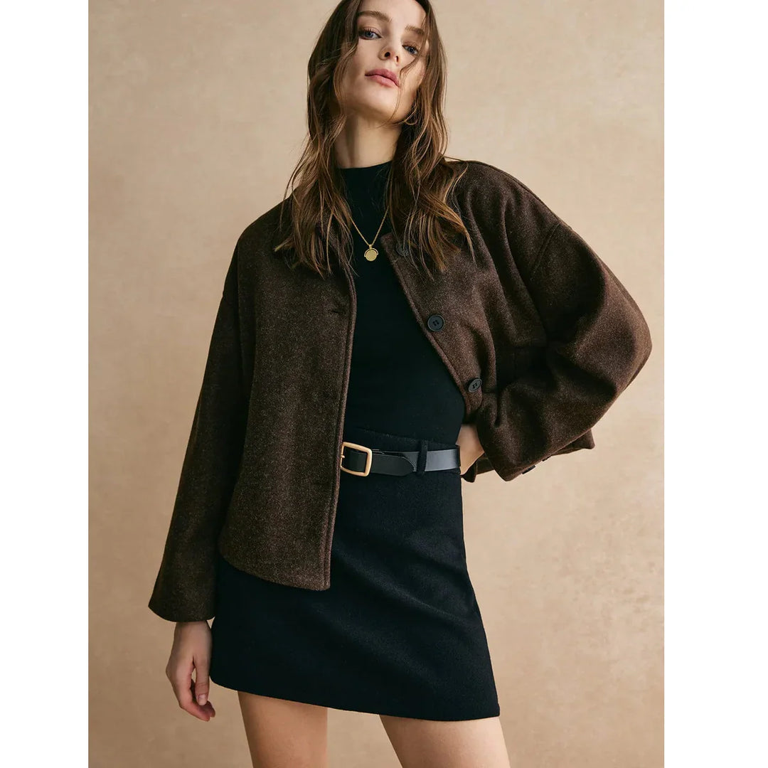 Woman modeling brown jacket and black skirt with belt, Rovelli fashion collection