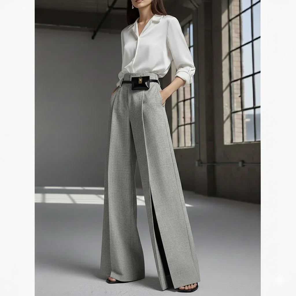 Woman in Rovelli Bryle pleated split trousers and white blouse in modern loft