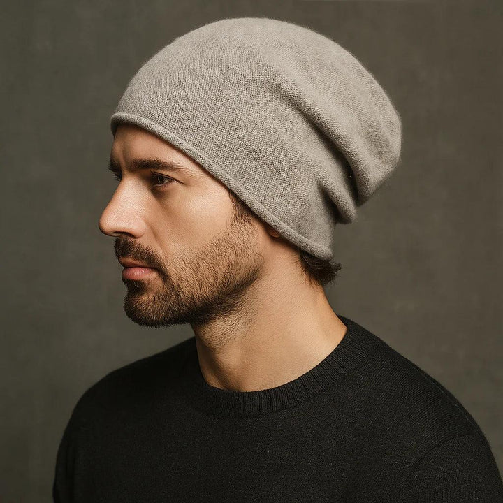 Man wearing brown cashmere beanie from Rovelli against dark background