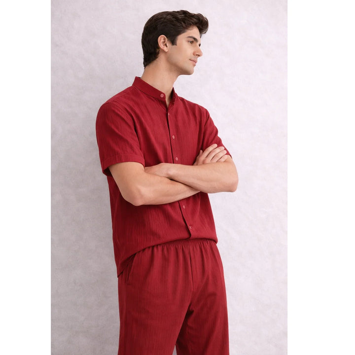 Man wearing Rovelli red textured lounge set, short sleeve shirt and pants, neutral background