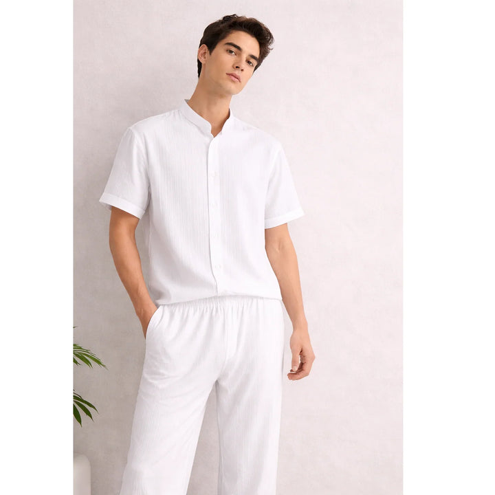 Man wearing Rovelli white textured lounge set with short sleeves and button-up shirt