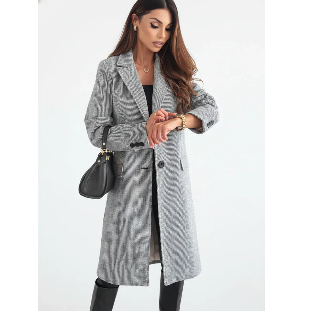Woman modeling a gray long coat with black handbag, stylish winter fashion on Rovelli