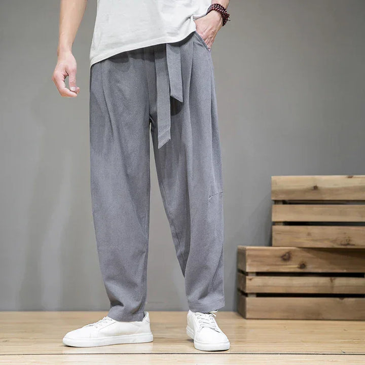 Rovelli relaxed fit gray pants with belt, styled with white sneakers on wooden floor