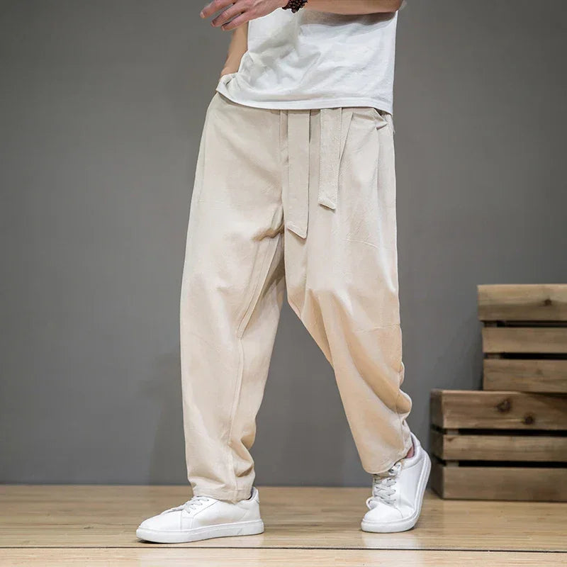 Rovelli beige loose fit pants with tie waist, casual style, white sneakers, wood floor
