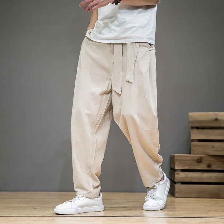 Rovelli beige loose fit pants with tie waist, casual style, white sneakers, wood floor