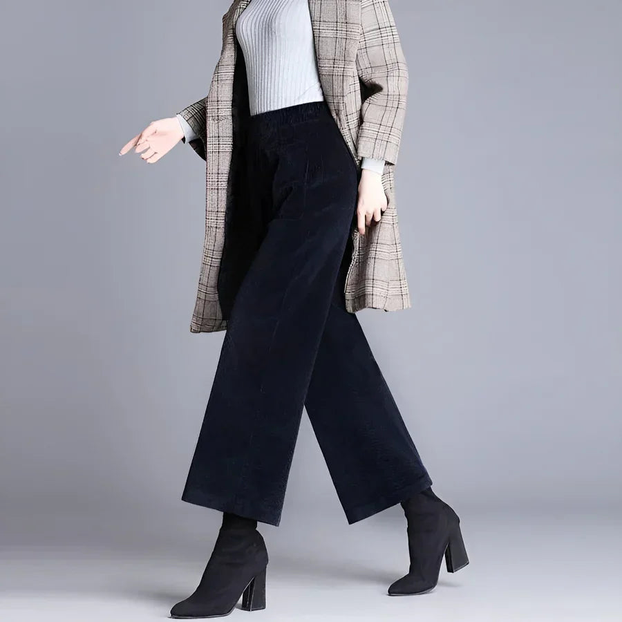 Rovelli wide-leg black pants with plaid coat and heeled boots on gray background