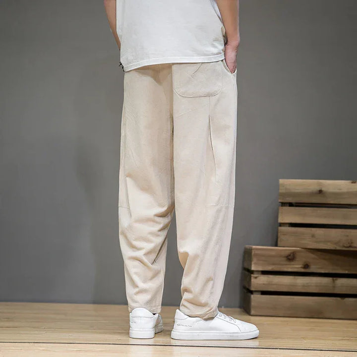Rovelli beige casual pants with side pocket, white sneakers, indoor wooden floor