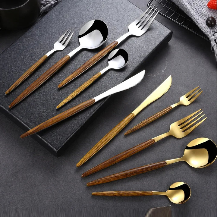 A stainless steel cutlery set featuring forks, spoons, and knives with wooden handles and metallic heads in silver and gold, neatly arranged on a black surface.