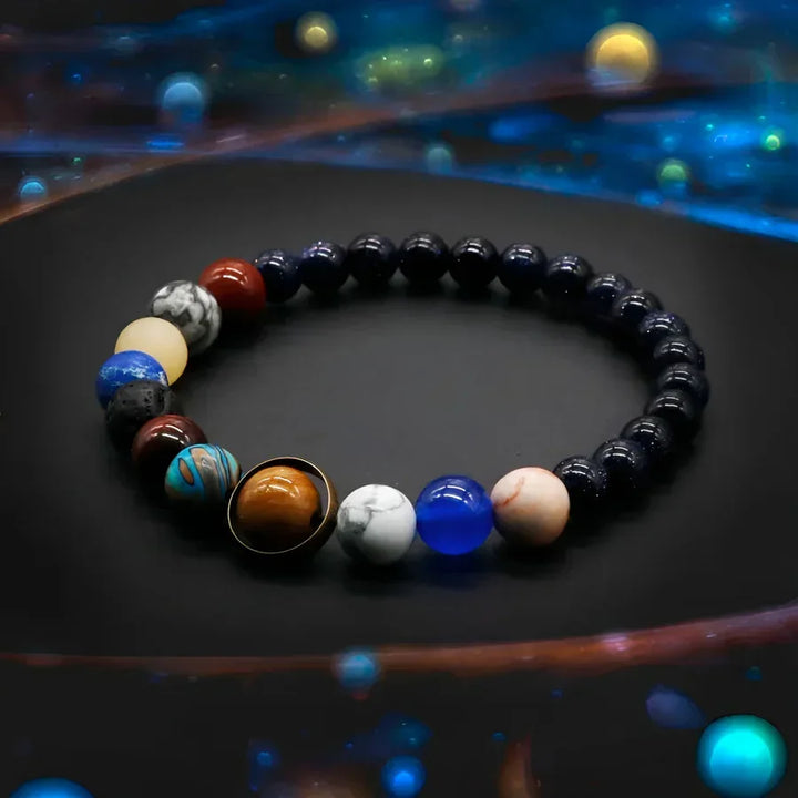 Rovelli beaded solar system bracelet with colorful planet stones on a dark cosmic background