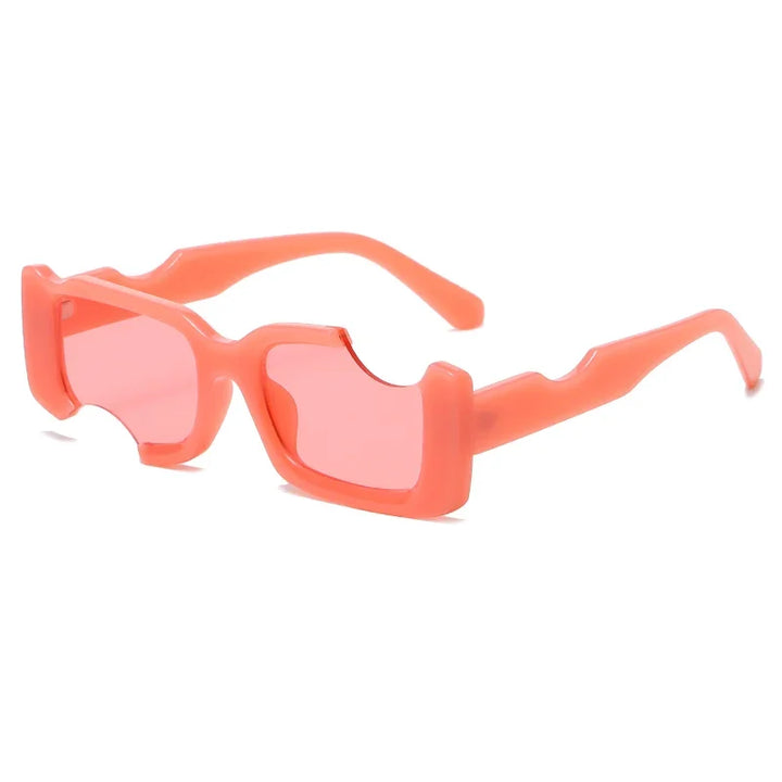 Bright pink sunglasses with geometric frames and rectangular shapes, featuring angular cutouts on the top of the lenses and arms. The tinted pink lenses match the bold, modern plastic frame—perfect for a street style look.