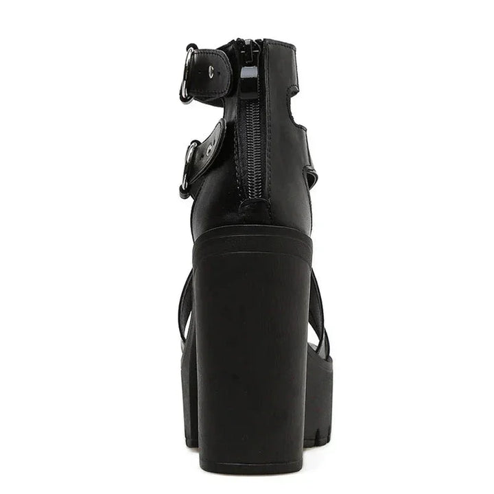 Rear view of black platform women sandals with a thick block heel, open toe, ankle straps with buckles, and a zipper running down the back for closure.