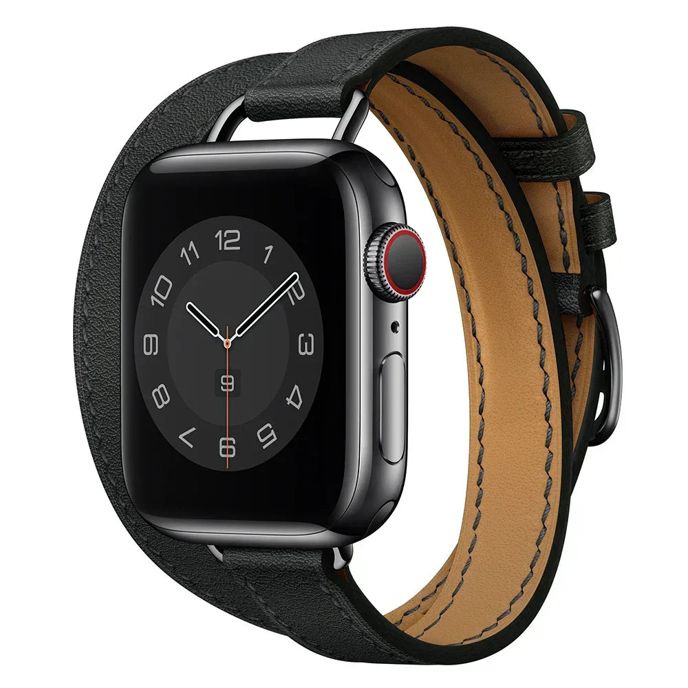A black smartwatch with a square face displaying an analog clock, shown with a silver case and a Genuine leather Apple Watch band in a double wrap design, featuring adjustable sizing, isolated on a white background.