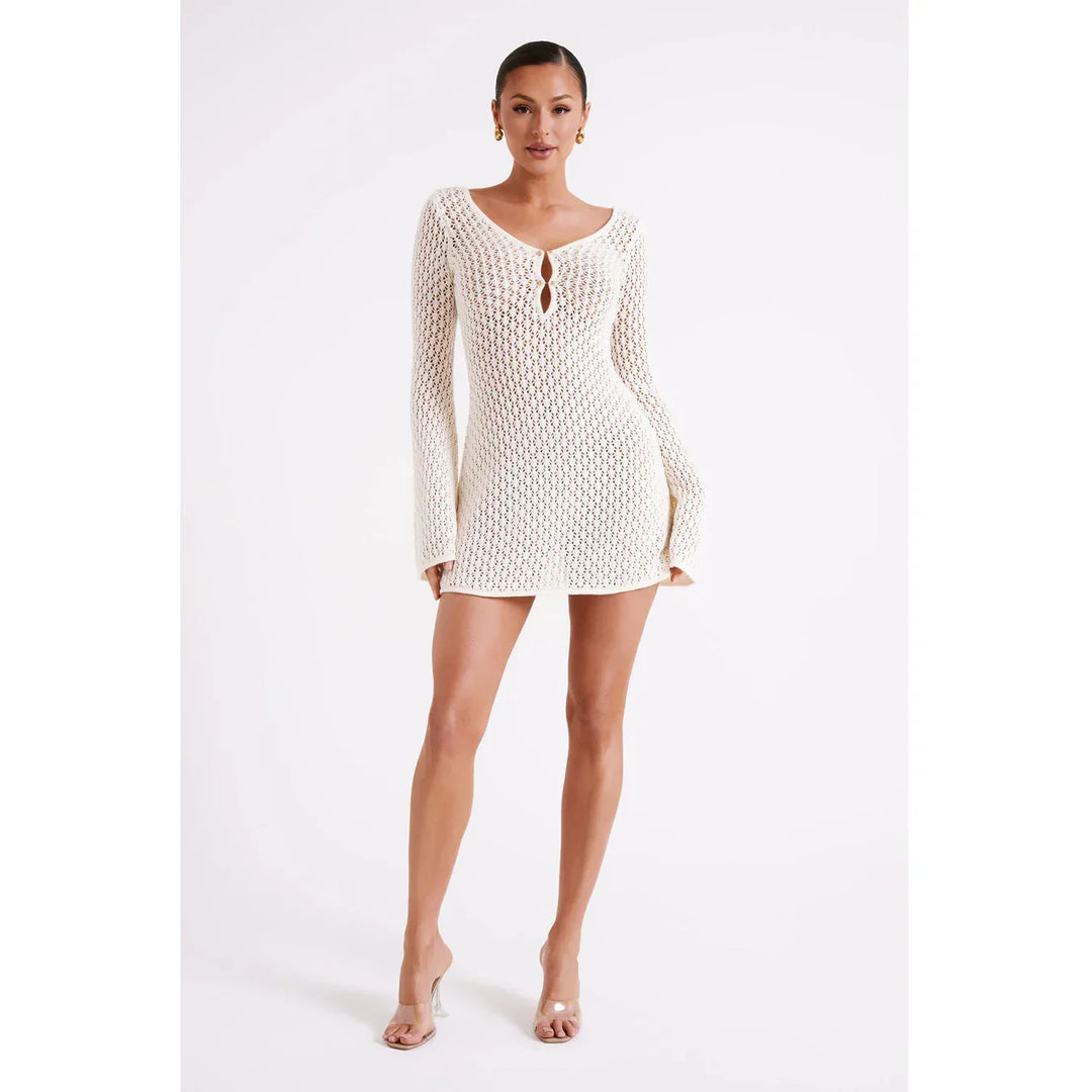 Woman wearing white crochet knit mini dress with long sleeves, Rovelli fashion