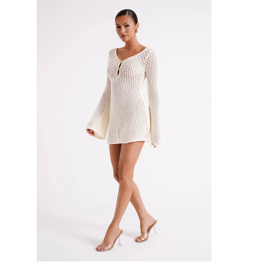 Woman in cream crochet mini dress with long sleeves and clear heels, Rovelli fashion
