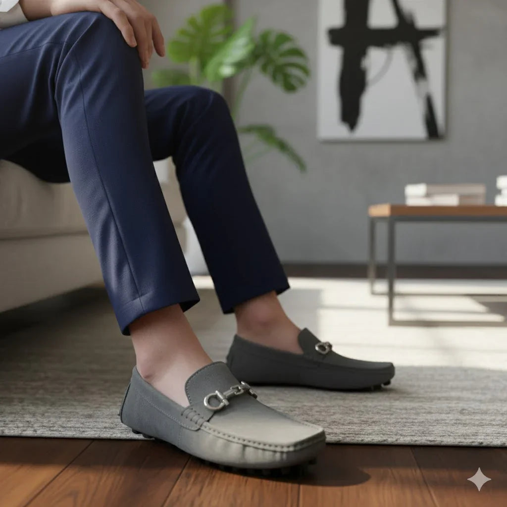 Rovelli gray driving moccasins on person seated in modern living room, stylish footwear.